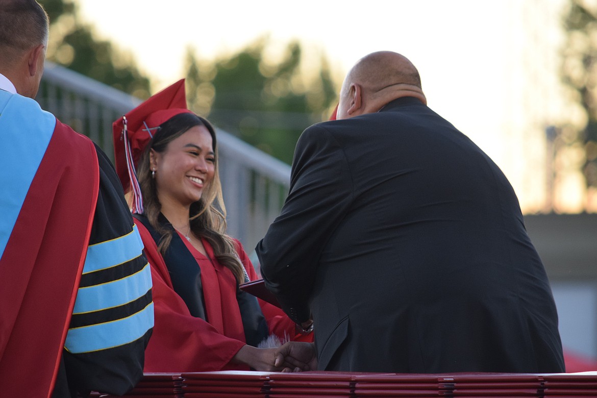 An Othello High School graduating senior accepts her diploma Friday.