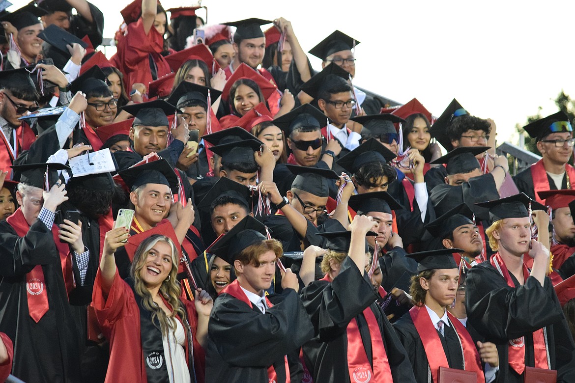 Members of the Othello High School Class of 2024 move their tassels to the other side of their caps, marking the certification of their graduation from the Othello School District.