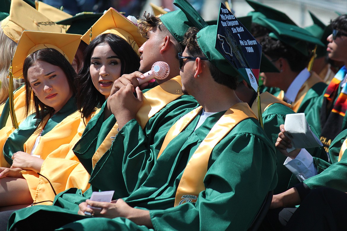 Graduation was a hot day and Quincy High School graduates were out there in two layers of clothing, so one graduate cooled off with the help of a handheld fan.