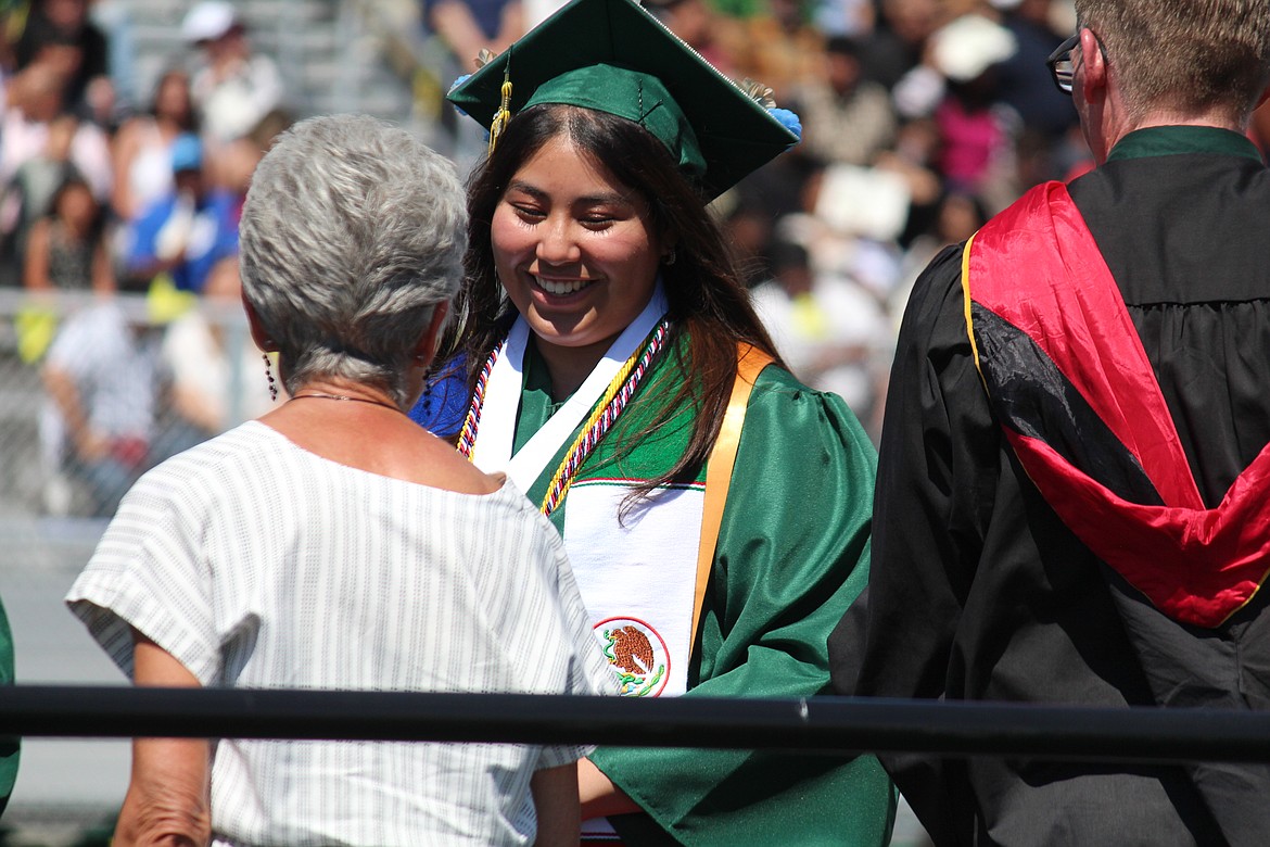 A member of the Quincy High School class of 2024 accepts her diploma.