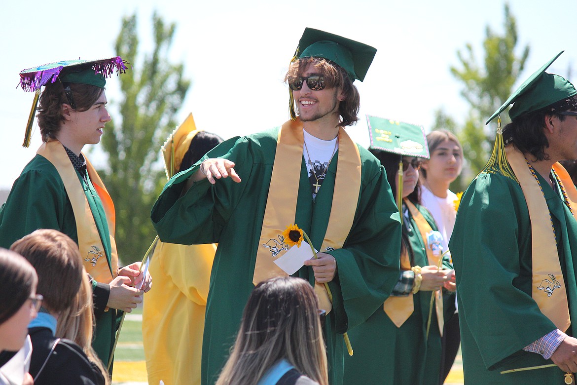 A Quincy senior exchanges jokes with a teacher as he waits for his diploma.