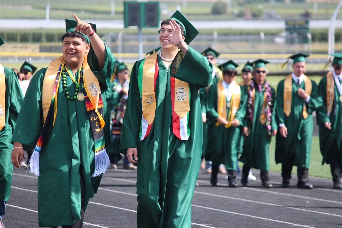 Seniors in the Quincy class of 2024 find and wave to family members in the crowd during the processional.