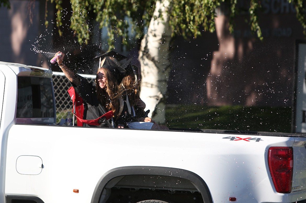 A Royal High School graduate sprays silly string during the graduation parade on Friday evening.