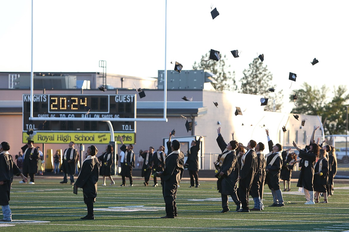 Royal High School graduates toss their caps into the air following Friday’s graduation ceremony.