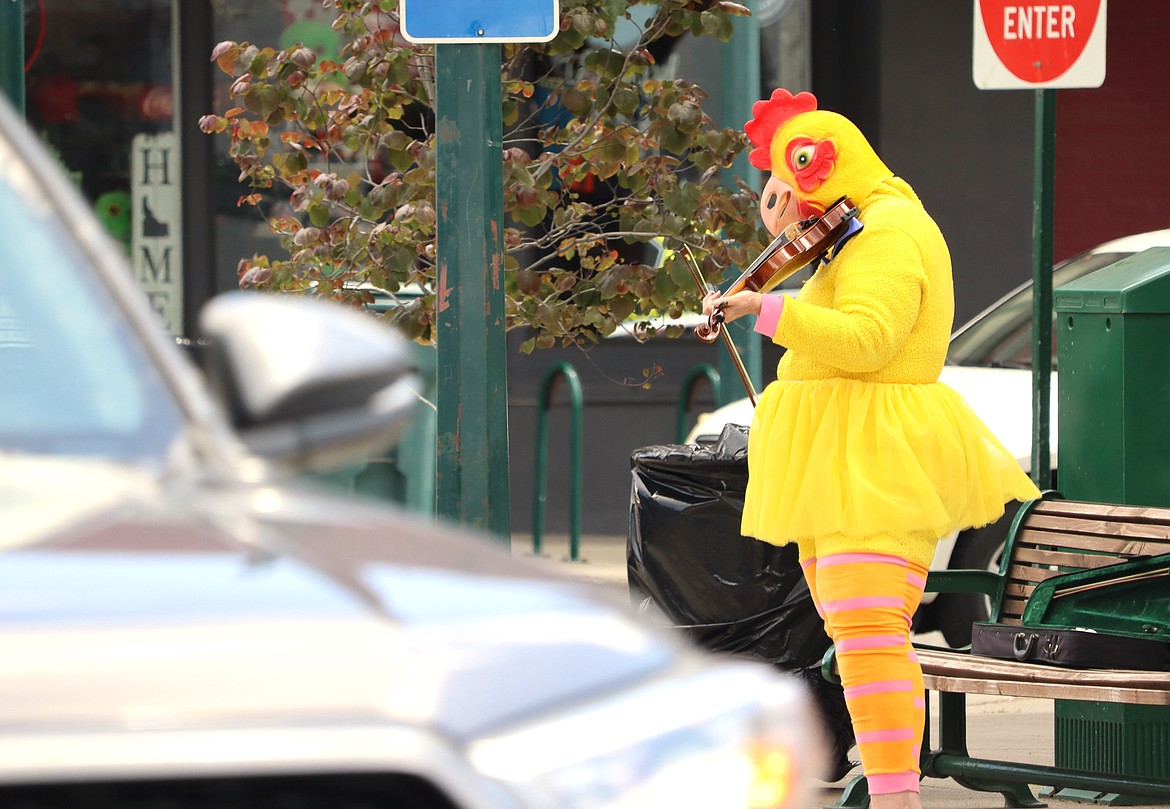 Linda Hitt performs with her violin in a chicken outfit on Monday for Street Music Week in downtown Coeur d'Alene.