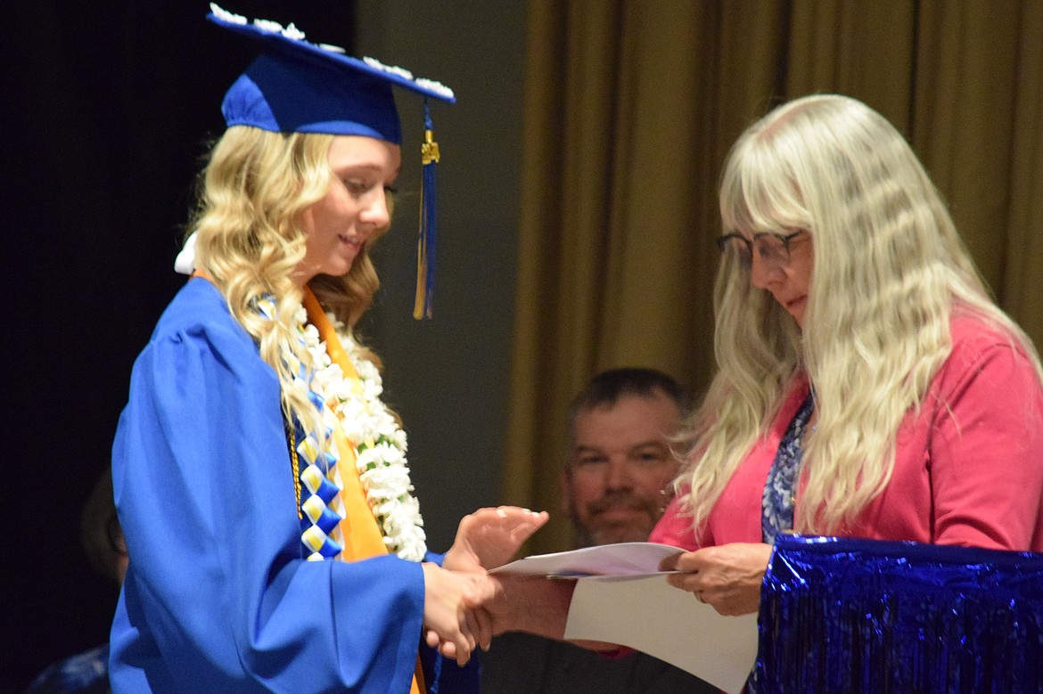 Wilson Creek Class of 2024 Valedictorian Isabella Hochstatter, left, accepts a scholarship award from Superintendent Laura Christian, right, during this year’s graduation ceremony.