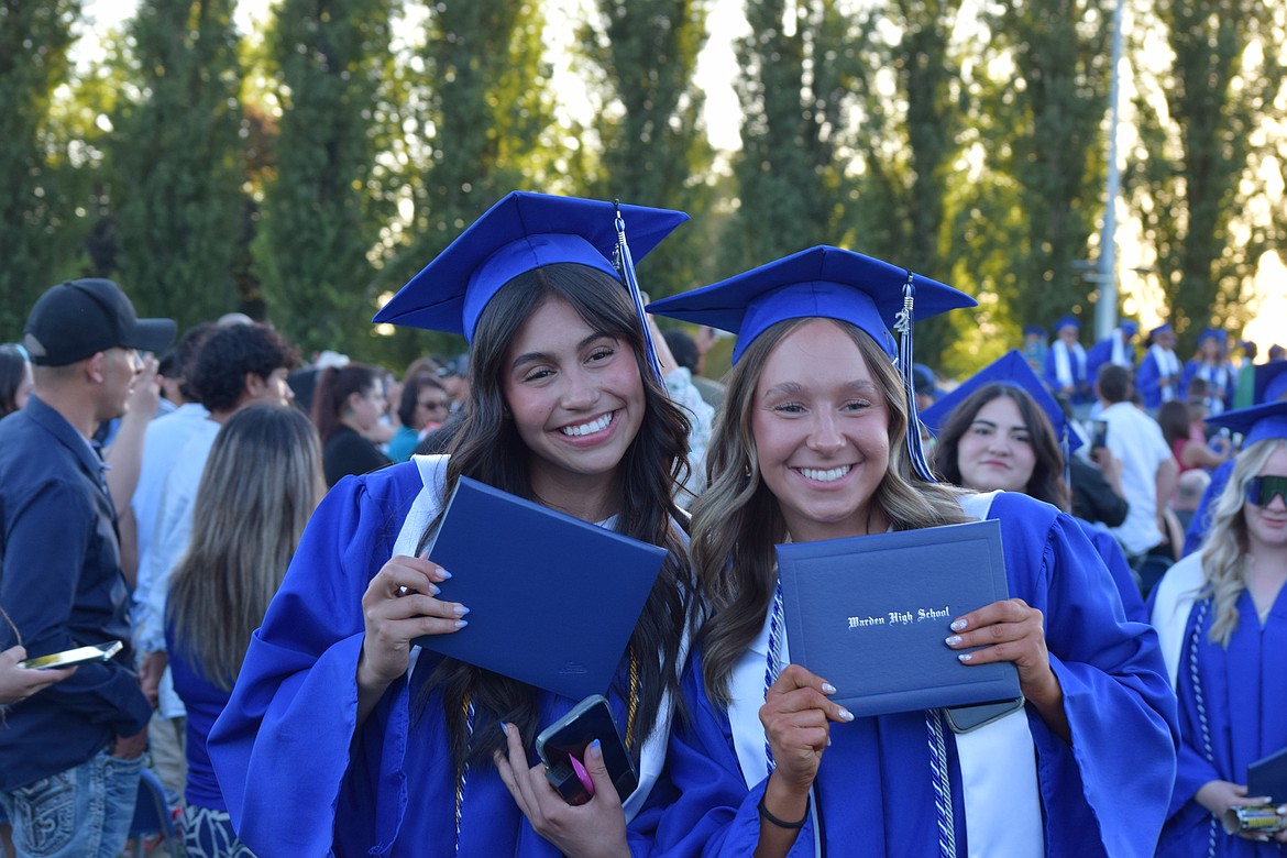 Two Cougar grads show off their diplomas after walking the stage over the weekend. Dozens of students earned their diplomas as part of the Warden Class of 2024.