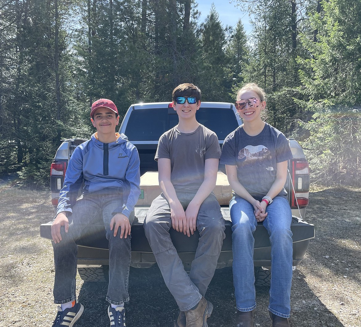 From left, Breckham Noble, Kyler Heilman and Rebecca Heilman sit on the back of a pick-up truck after a shoot. The trio will be heading to the Idaho Trap Shooting State Tournament this Saturday at the Boise Gun Club in Kuna.
