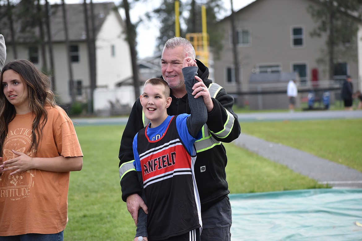 Sixth-grader Lincoln Singer of Canfield Middle School gets a hug from his dad, Raymond Singer during the Lakeland Life Skills Track and Field Invitational. Left: Julianna Hasso is an eighth-grade mentor in the partners in learning peer mentor program who came to assist with the track meet.