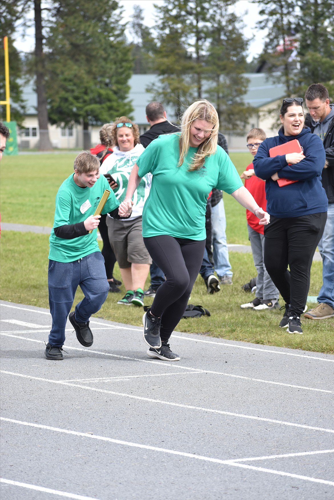 Lakeland Middle School sixth-grader Blaiden Stallcup runs hand in hand with Life Skills teacher Rebecca Koziol at the start of the 4X100 relay.