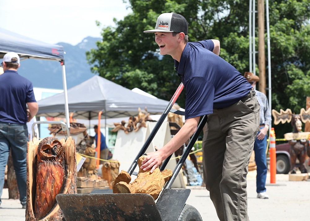 FFA member Saddler McCollum helped load up chainsaw sculptures for one of the auctions held during the Mission Valley Chainsaw Carving Rendezvous. (Susan Lake photo)