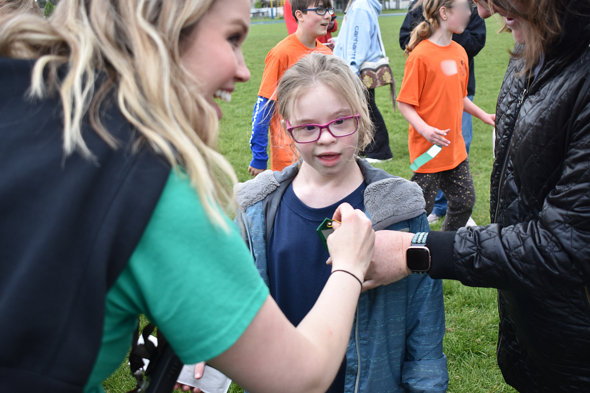 River City Middle School seventh-grader Heather Howell receives her ribbon from Lakeland Middle School activities director Francesca Myers.