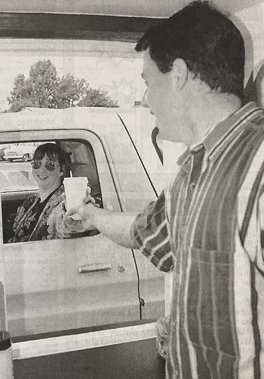 Mary Spray receives her first free latte from Greg Windju of Latte Chalet.