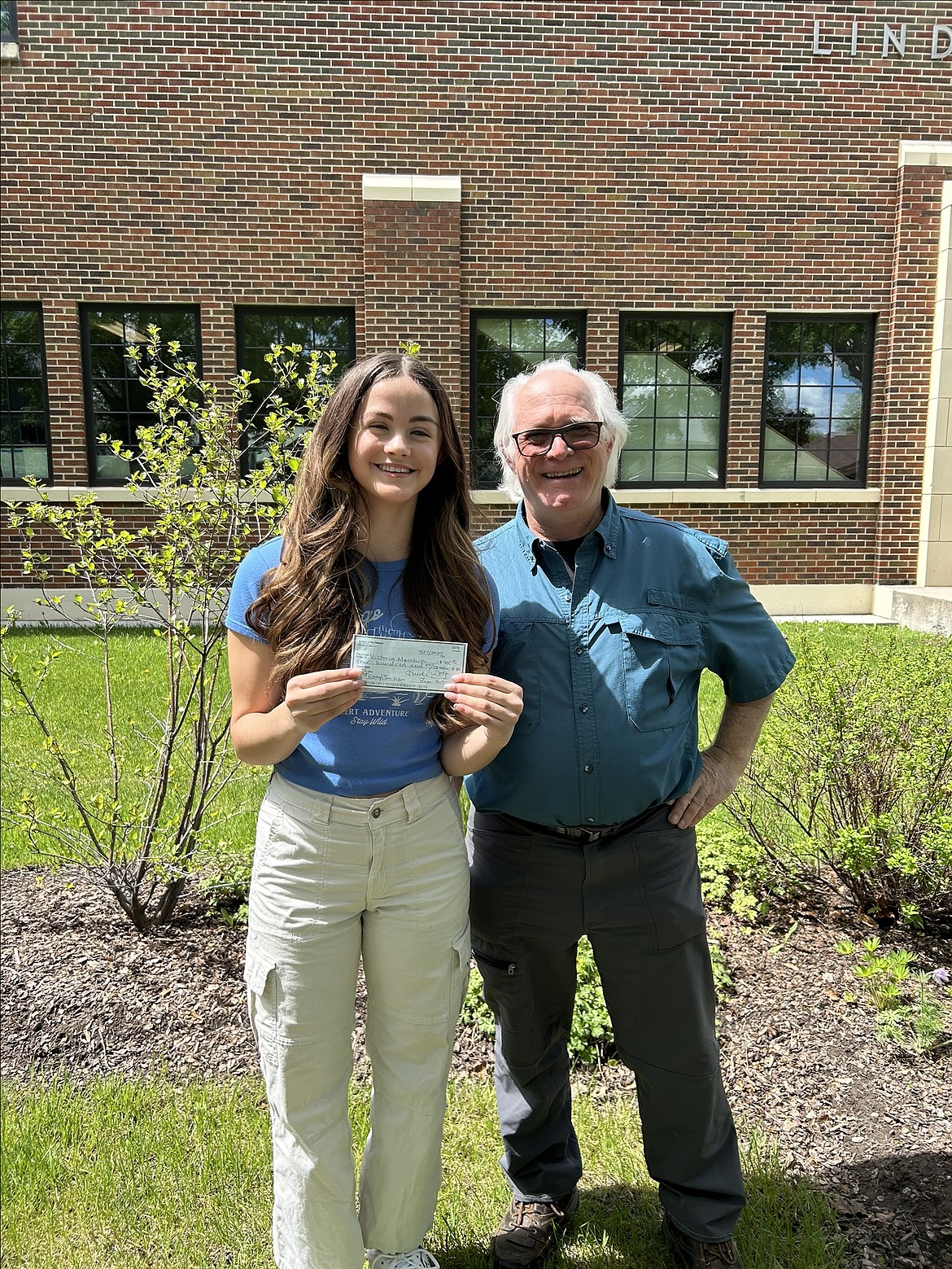 Linderman student Victoria Meccia, who won third place in the fiction category, gets a check from Craig Naylor with Authors of the Flathead. (Courtesy photo)