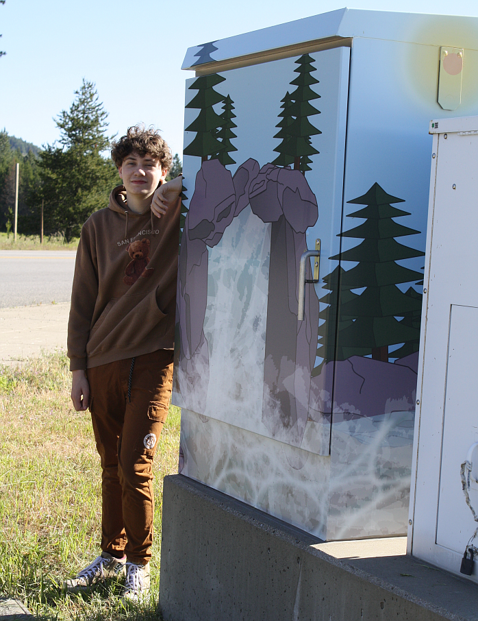 Coen Willis stands with his original design on the electrical box north of the Highway 41 overpass bridge in Rathdrum.