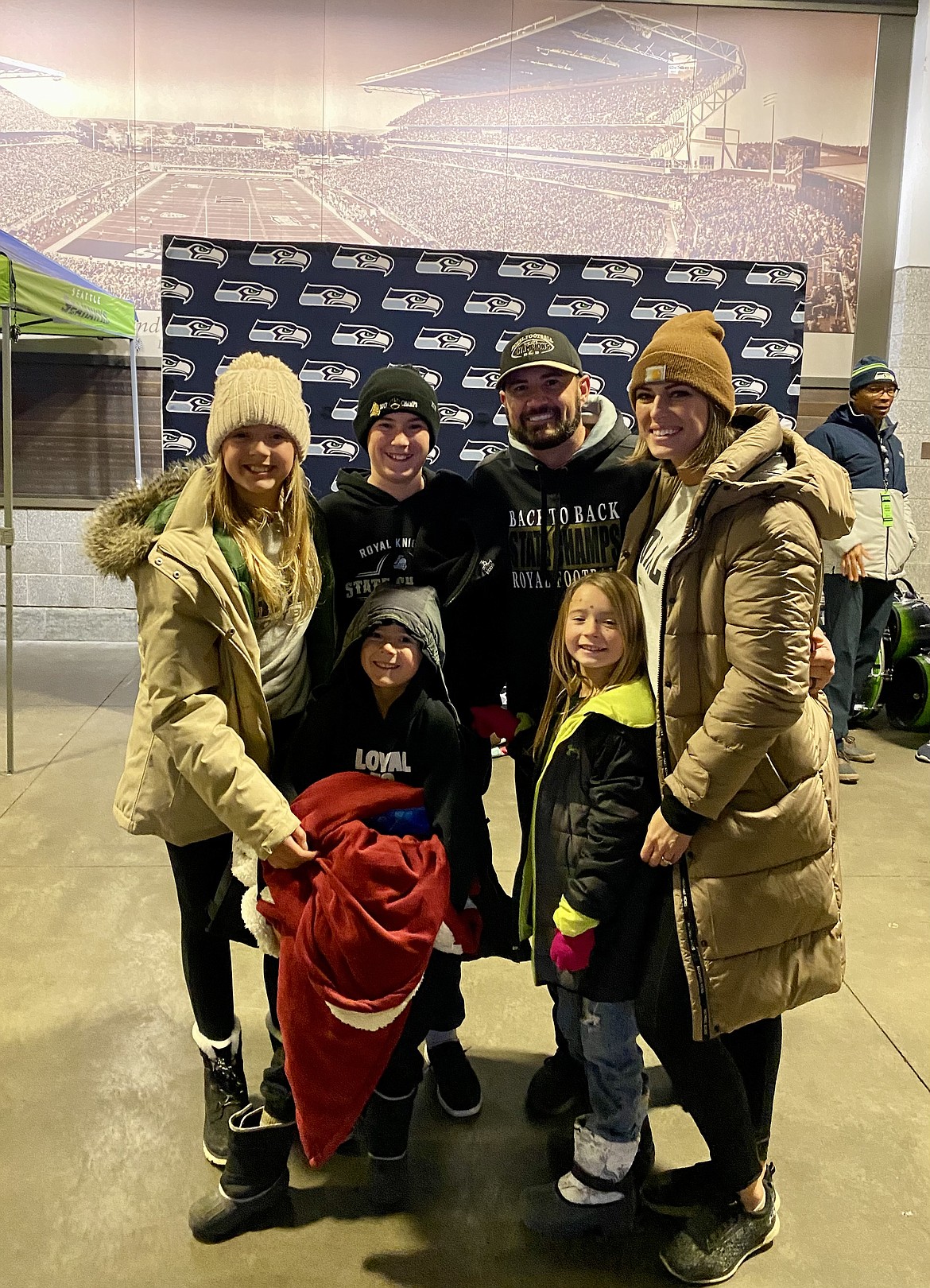 Royal Defensive Coordinator Jeremy Scroggins, back row center right, smiles with family after the Knights defeated Lakeside (Nine Mile Falls) in the 1A state championship game in Seattle in December.