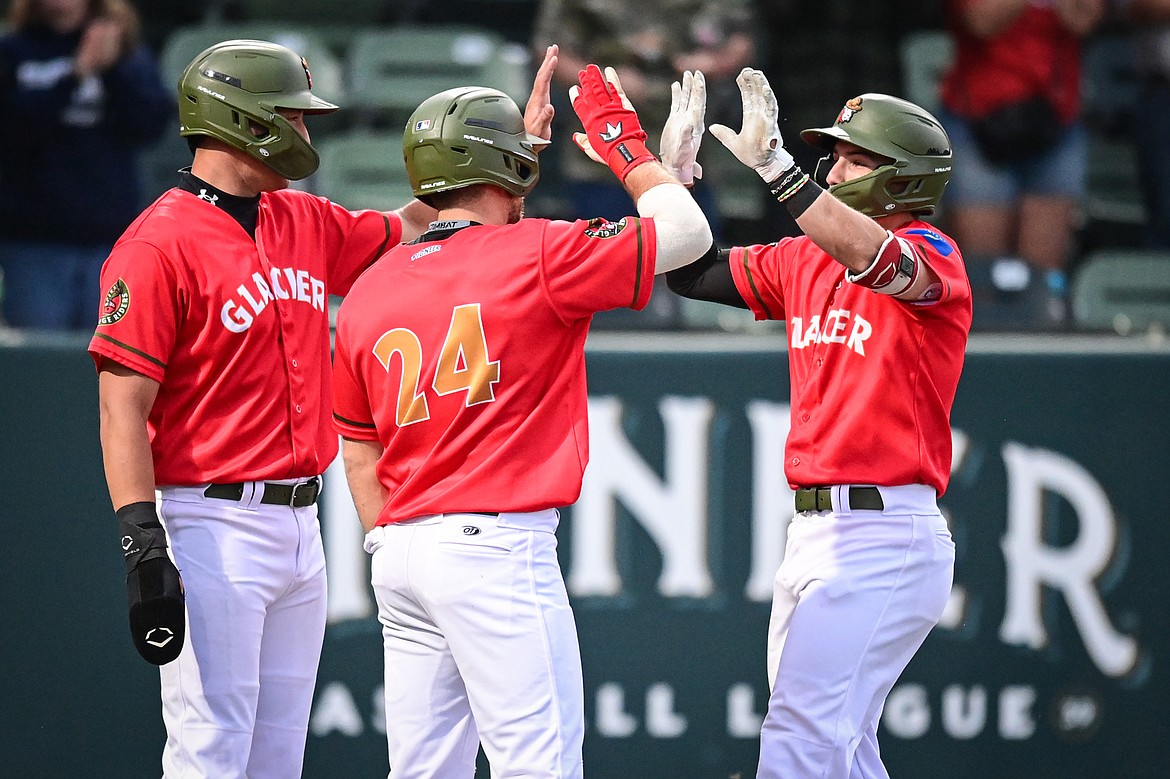 Glacier's Christian Kirtley (1) celebrates with Chad Castillo (28) and Ajay Szcepkowski (24) after hitting a three-run home run in the fifth inning against the Idaho Falls Chukars at Glacier Bank Park on Friday, June 14. (Casey Kreider/Daily Inter Lake)