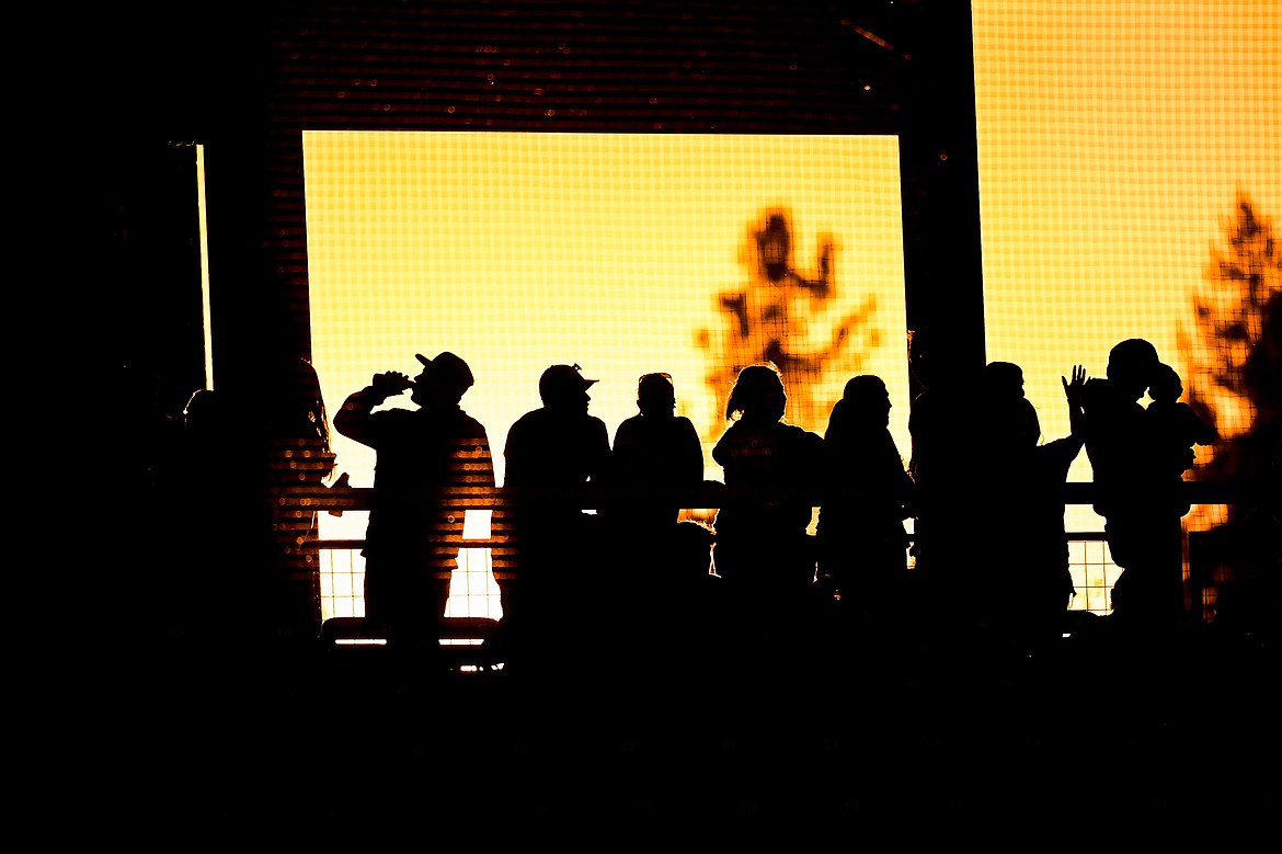 Range Riders fans watch from the concourse as the sun sets in the sixth inning as Glacier plays the Idaho Falls Chukars at Glacier Bank Park on Friday, June 14. (Casey Kreider/Daily Inter Lake)