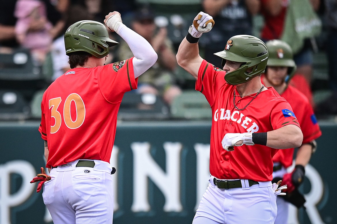 Glacier's Gavin Tonkel (5, right) celebrates with Jerry Huntzinger (30) after Tonkel's two-run home run in the third inning against the Idaho Falls Chukars at Glacier Bank Park on Friday, June 14. (Casey Kreider/Daily Inter Lake)