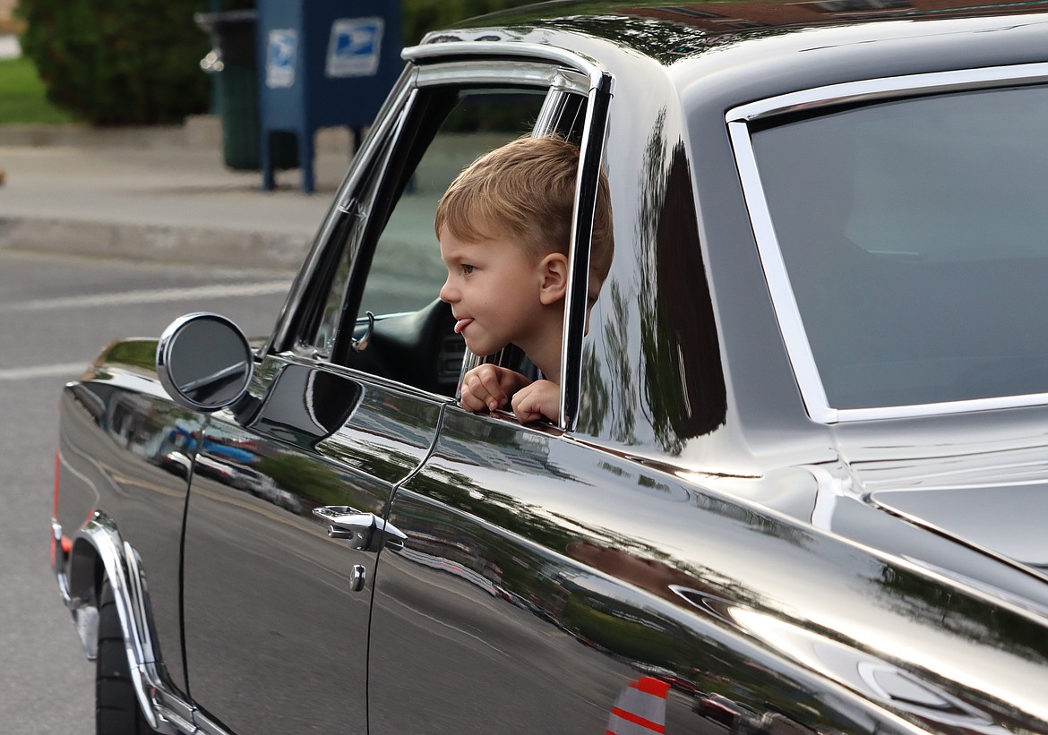 A boy pokes his head out from an entry in Car d'Lane.