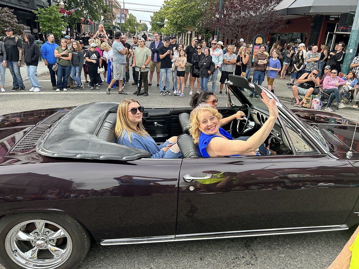 People wave as they ride on Sherman Avenue in Car d'Lane on Friday.