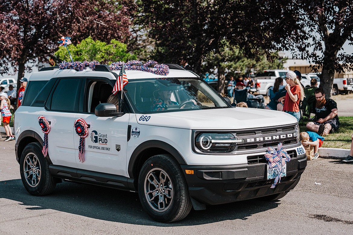 A bunting-bedecked PUD vehicle takes to the street at the 2023 July 4 parade in George.