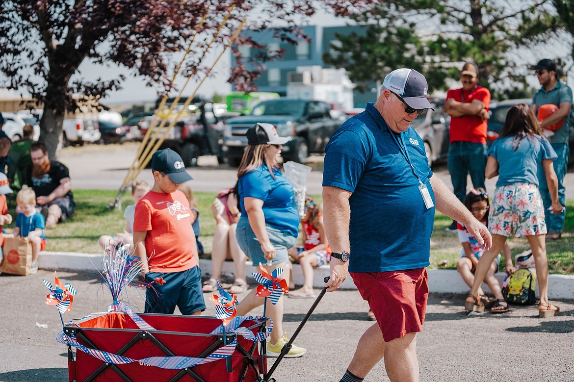 Grant County PUD employees and family members with the candy wagon at the 2023 July 4 parade.