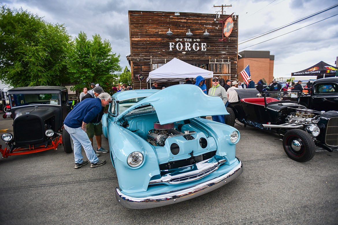 Attendees check out rows of vehicles at The Big Shindig in Kalispell on Saturday, June 15. The Big Shindig features a wide range of classic and custom vehicles as well as live music, barbeque, beer and wine and a pin-up polar plunge. Hosted the Glacier Street Rod Association and the Desoto Grill, money raised benefits Mikayla’s Miracles and Blessings Foundation. (Casey Kreider/Daily Inter Lake)