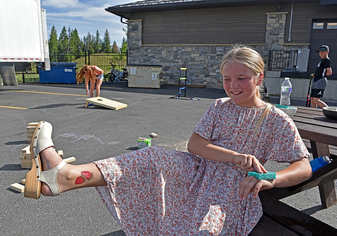 Kids get excited about fruits and vegetables with temporary tattoos at the NVFB Forever June celebration Friday. (Kelsey Evans/Whitefish Pilot)