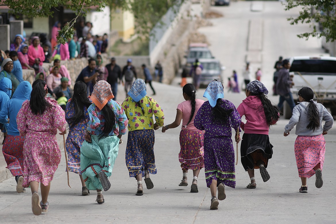 Rarámuri women runners compete in the Arihueta race in Cuiteco, Mexico, Saturday, May 11, 2024. Nestled in a remote mountain range in northern Mexico, the Tarahumaras, who identify themselves as Rarámuris, got used to running to cope with long distances, scarcity and isolation. (AP Photo/Eduardo Verdugo)