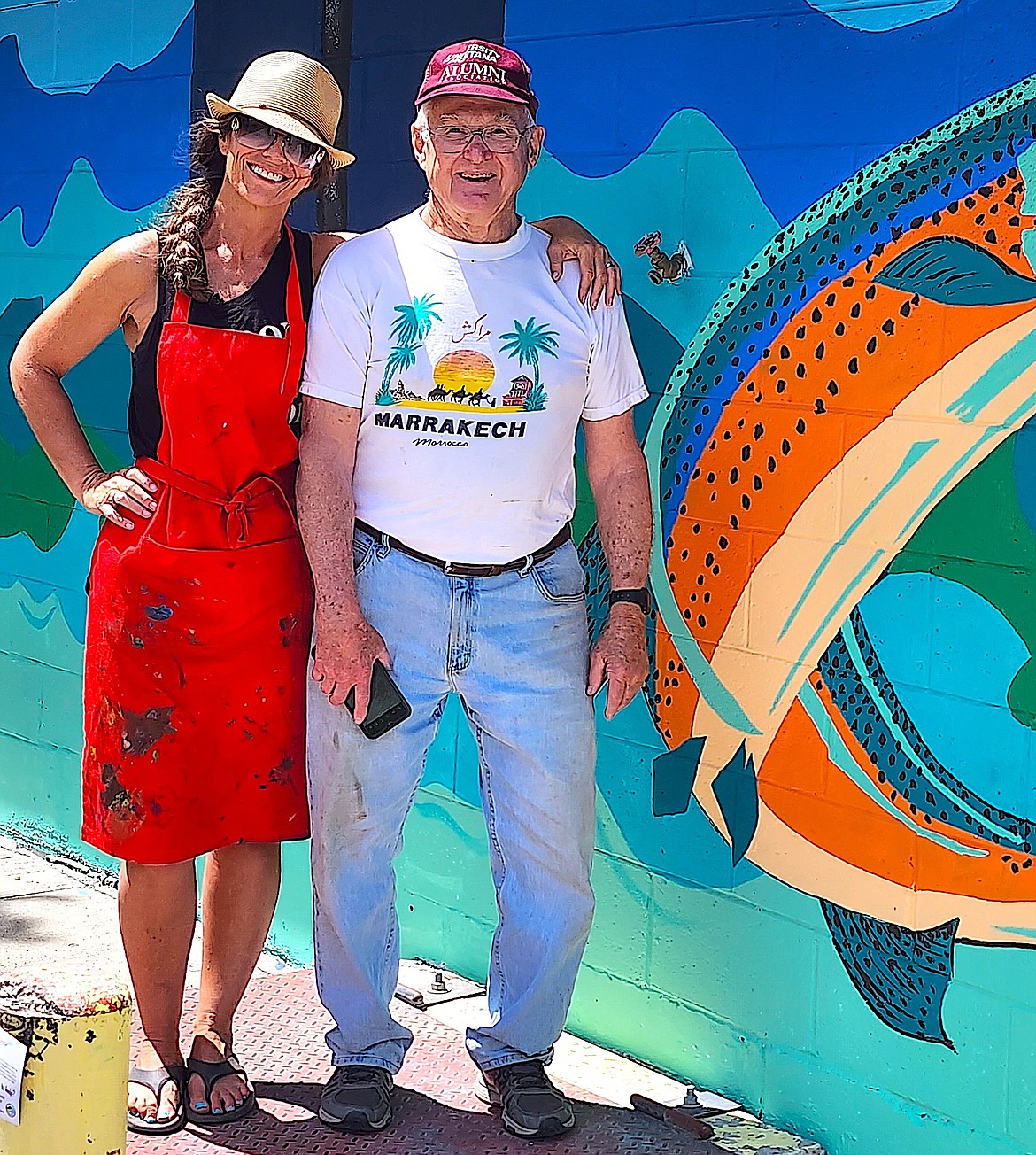 Sandpiper members Jess Bouchee and Charlie Fudge, who's in charge of the mural project, stand in front of the finished lake scene. (Berl Tiskus/Leader)