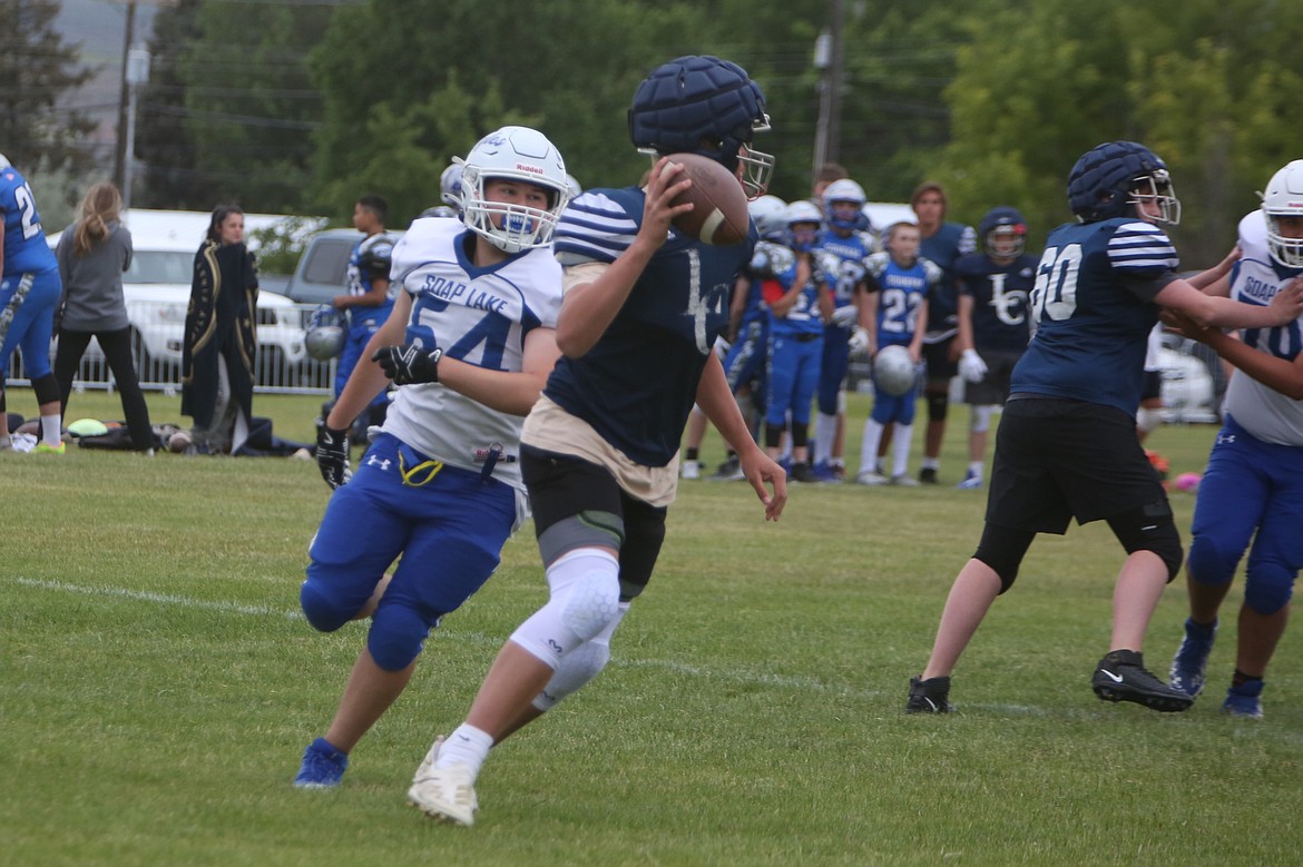 A Soap Lake defender closes in on a Liberty Christian quarterback during Friday’s jamboree in Coulee City.