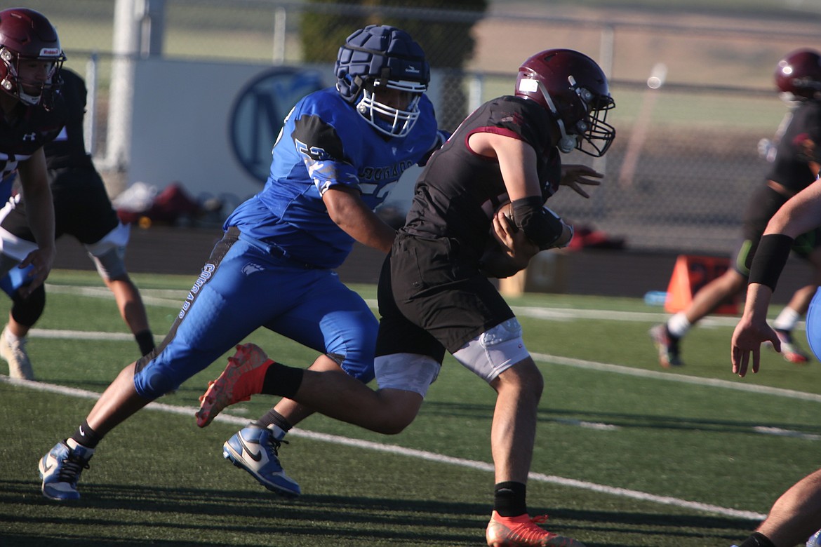 A Warden defender dives in to attempt a tackle against a Wahluke running back.