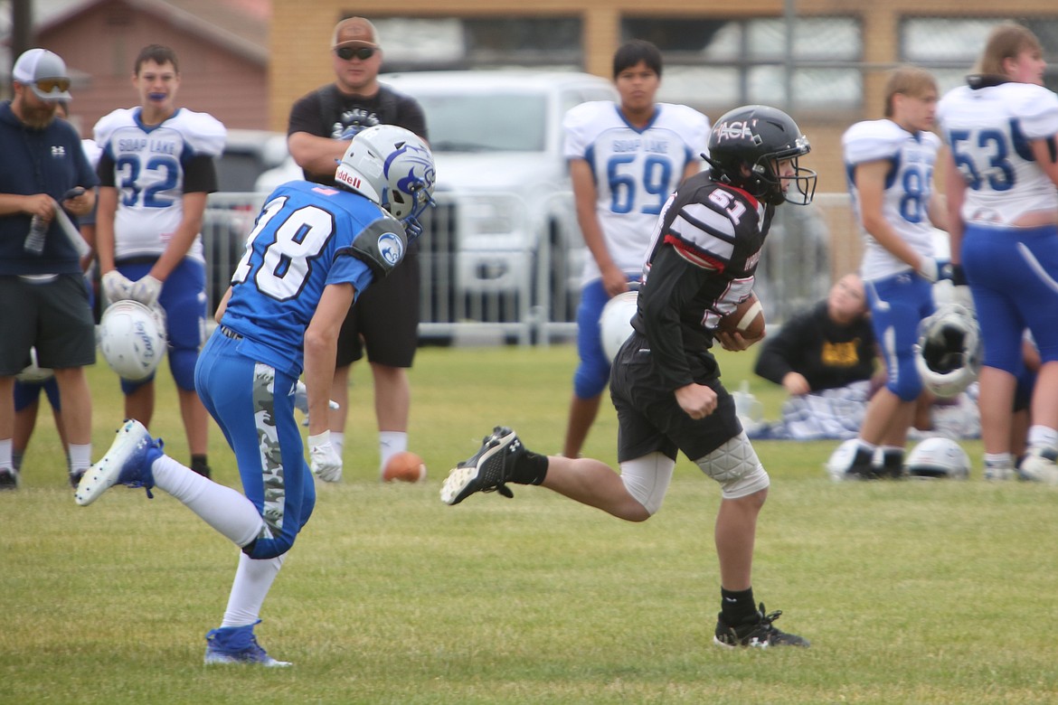 An Almira/Coulee-Hartline running back rushes past a Curlew defender during a scrimmage on Friday in Coulee City.