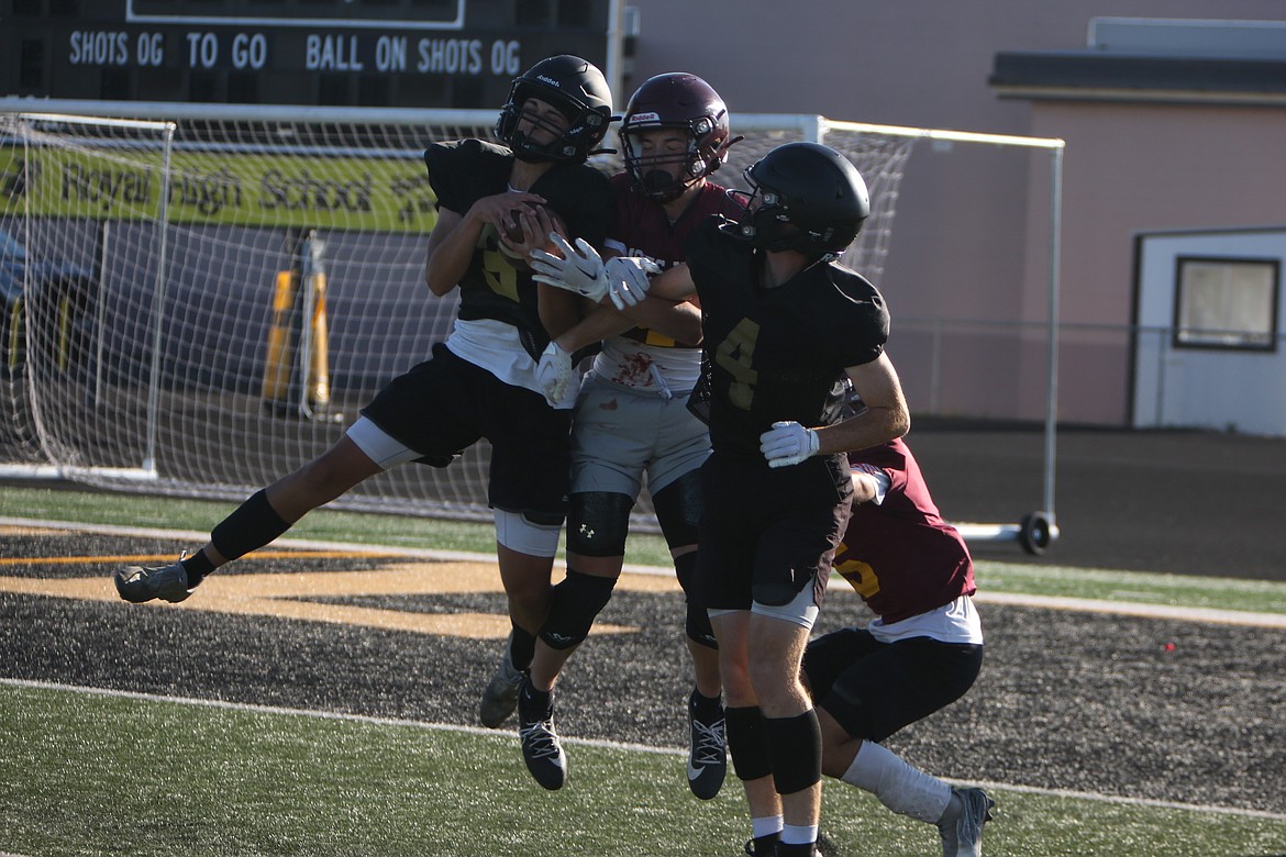 A group of Royal defensive backs cover a Maverick receiver, with one coming down with an interception during a June 11 scrimmage.