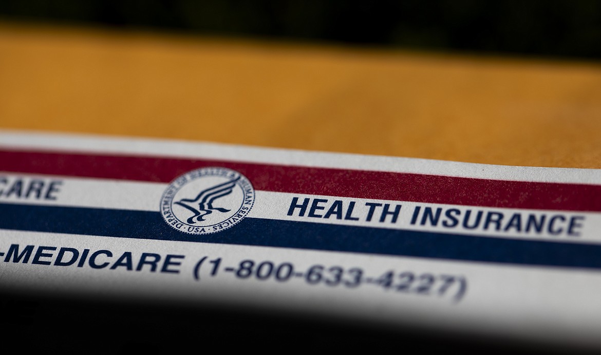 A shadow is seen across a Medicare card on June 10, 2024, in Portland, Ore. Majorities of Americans favor forgiving all or some of an individual's medical debt if the person is facing hardships, according to a new poll from the University of Chicago Harris School of Public Policy and The Associated Press-NORC Center for Public Affairs Research. (AP Photo/Jenny Kane)
