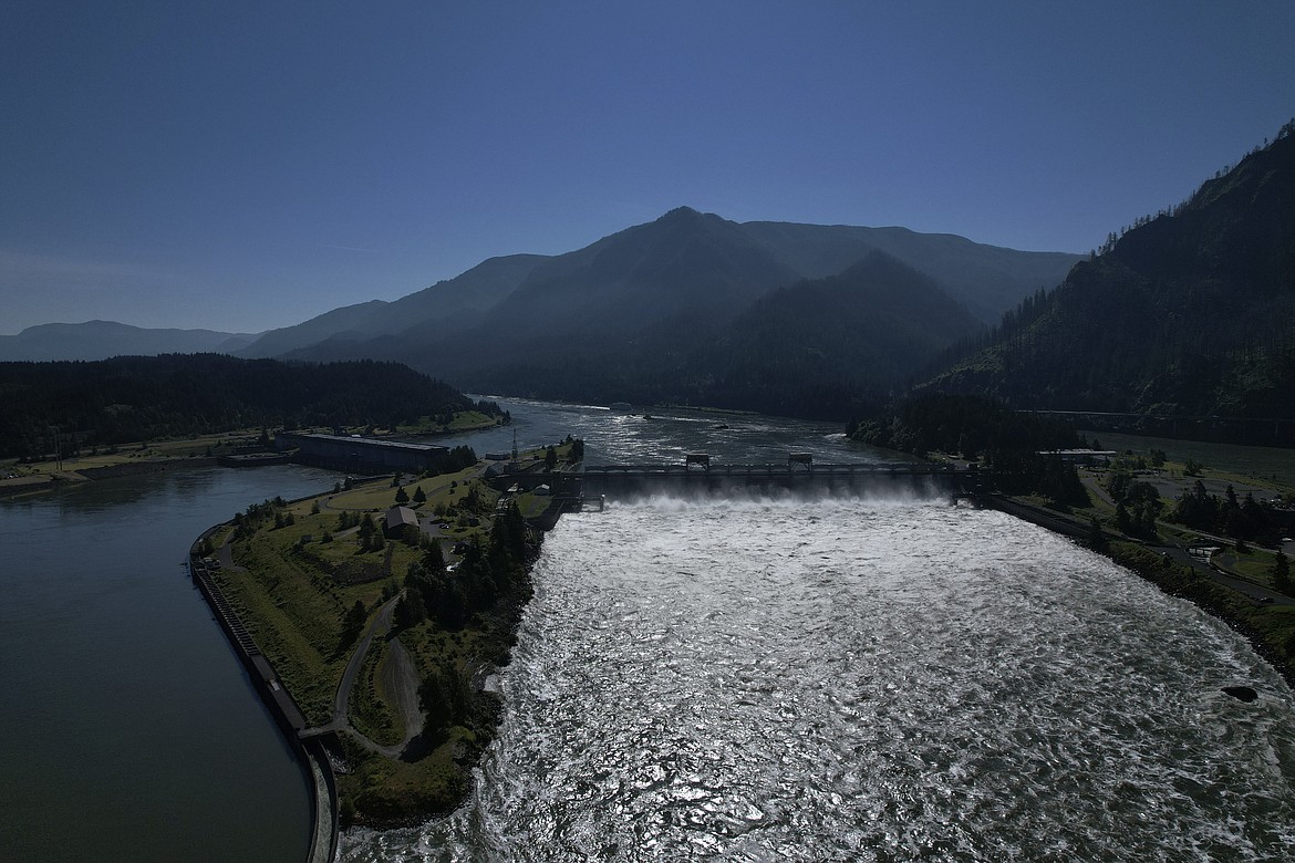 Water spills over the Bonneville Dam on the Columbia River, which runs along the Washington and Oregon state line, on Tuesday, June 21, 2022. The U.S. government on Tuesday, June 18, 2024, acknowledged for the first time the harms that the construction and operation of dams on the Columbia and Snake rivers in the Pacific Northwest have caused Native American tribes, issuing a report that details how the unprecedented structures devastated salmon runs, inundated villages and burial grounds, and continue to severely curtail the tribes' ability to exercise their treaty fishing rights. (AP Photo/Jessie Wardarski, File)
