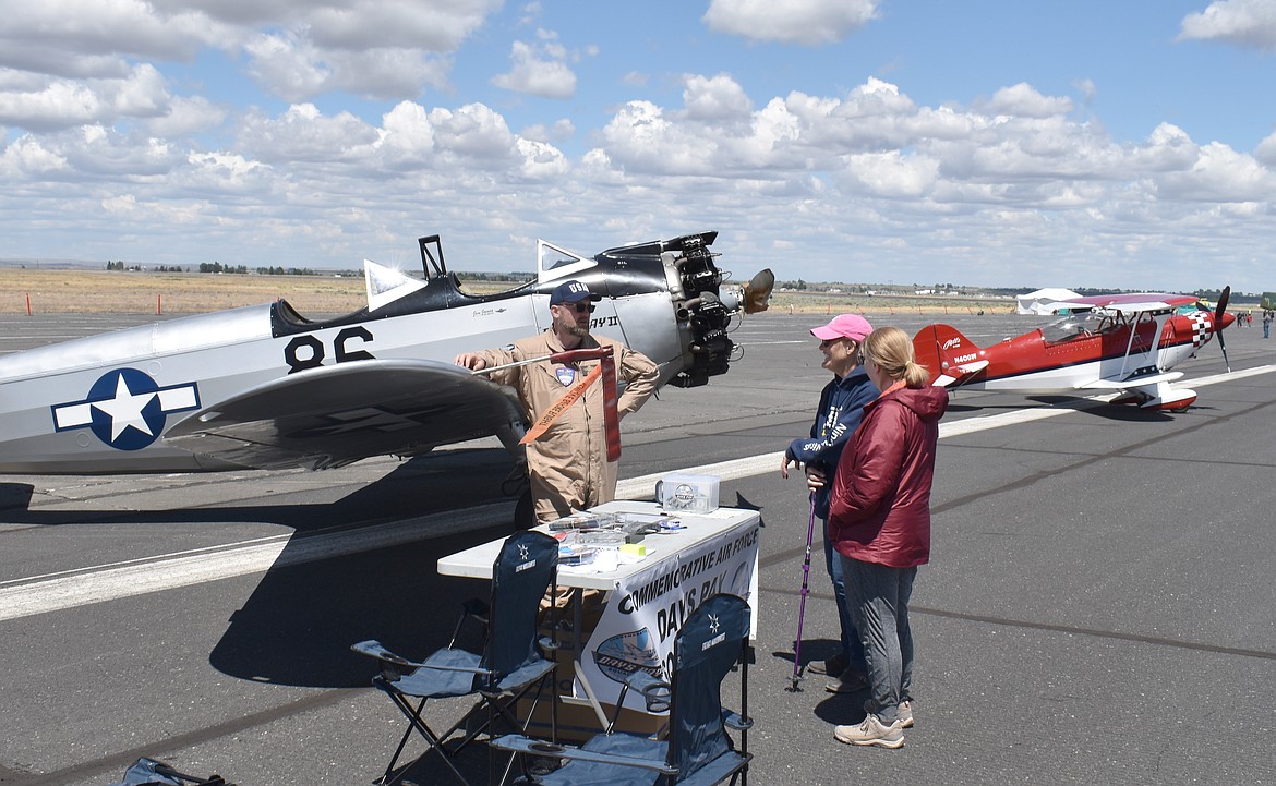 Jeff Hanoff, of the Commemorative Air Force, talks at the Moses Lake Airshow Sunday with Bonnie Molitor, left, and Aileen Coverdell. The women were representing The 99, an organization of women pilots established in 1929 by Amelia Earhart and 98 other aviatrixes. The 99 now numbers more than 7,500 members all over the world, they said.