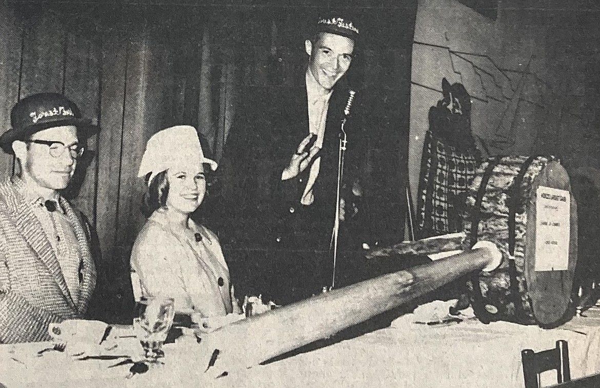 Carved from the historic Mullan Tree, a giant mallet, billed as the world’s largest gavel, was unveiled at a 1964 Forestry Festival Week lunch. Joining in the hilarity were, from left, 1964 Woodsman of the Year Nick Ormonde, Miss Coeur d’Alene X Janice Compton and featured speaker Dr. Howard Alden of the University of Idaho.