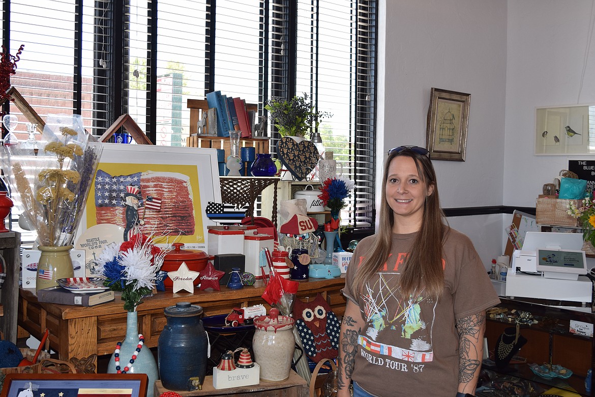 The Bluebird Boutique owner BreAnna Bridges stops for a photo in front of one of the home decor displays at the shop. Patriotic items are highlighted as the Independence Day holiday approaches.