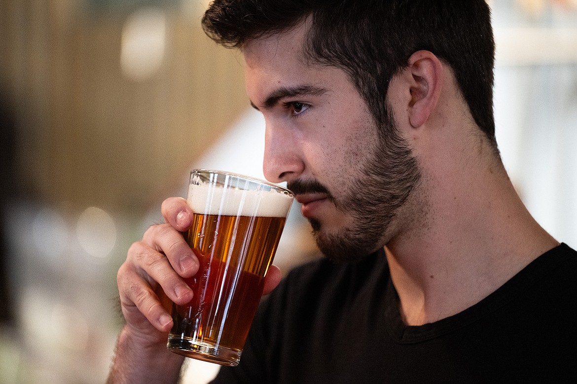 Student Christopher Maples smells the aroma of a freshly poured pint of an India Pale Ale while participating in a brewing session at Draught Works. (UM photo by Ryan Brennecke)