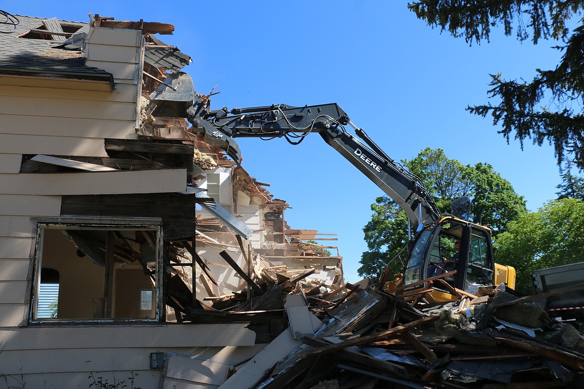 Jim Woodward of Apex Construction Services maneuvers into position to take a chunk out of an old duplex at Florence and Michigan. The site will eventually be home to multiple one-bedroom apartments, allowing the transitional housing program to help even more in the community.