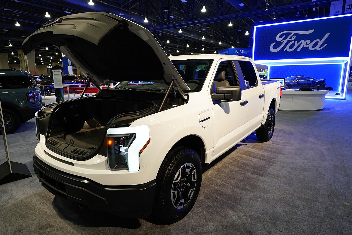 The Ford F-150 Lightning displayed at the Philadelphia Auto Show, Friday, Jan. 27, 2023, in Philadelphia. With U.S. electric vehicle sales starting to slow, Ford Motor Co. says, Thursday, April 4, 2024, it will delay rolling out new electric pickup trucks and a new large electric SUV as it adds gas-electric hybrids to its model lineup. (AP Photo/Matt Rourke, File