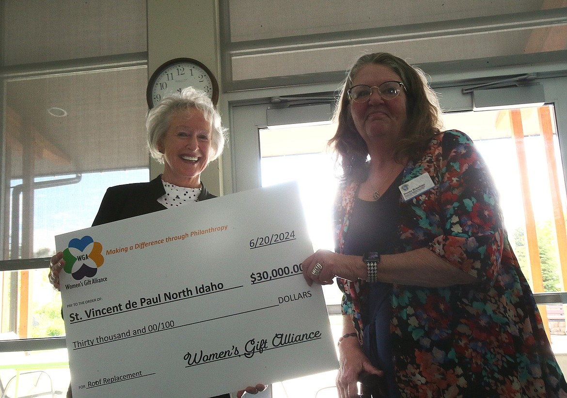 Joan Woodward, left, with the Women's Gift Alliance, presents a $30,000 check to Donna Brundage of St. Vincent de Paul North Idaho during an awards celebration Thursday. The alliance gifted $100,000 in pooled grants to five local nonprofits.