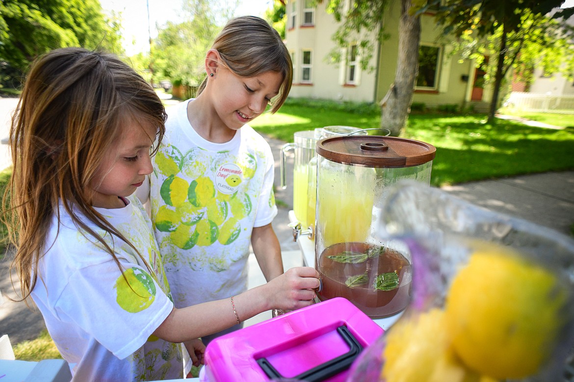 Lucy and Parker Waldenberg pour a cup of their Cherry Basil Lemonade at their 2 Sisters' Lemonade stand along Fifth Avenue East as part of the Lemonade Day program on Saturday, June 22. (Casey Kreider/Daily Inter Lake)