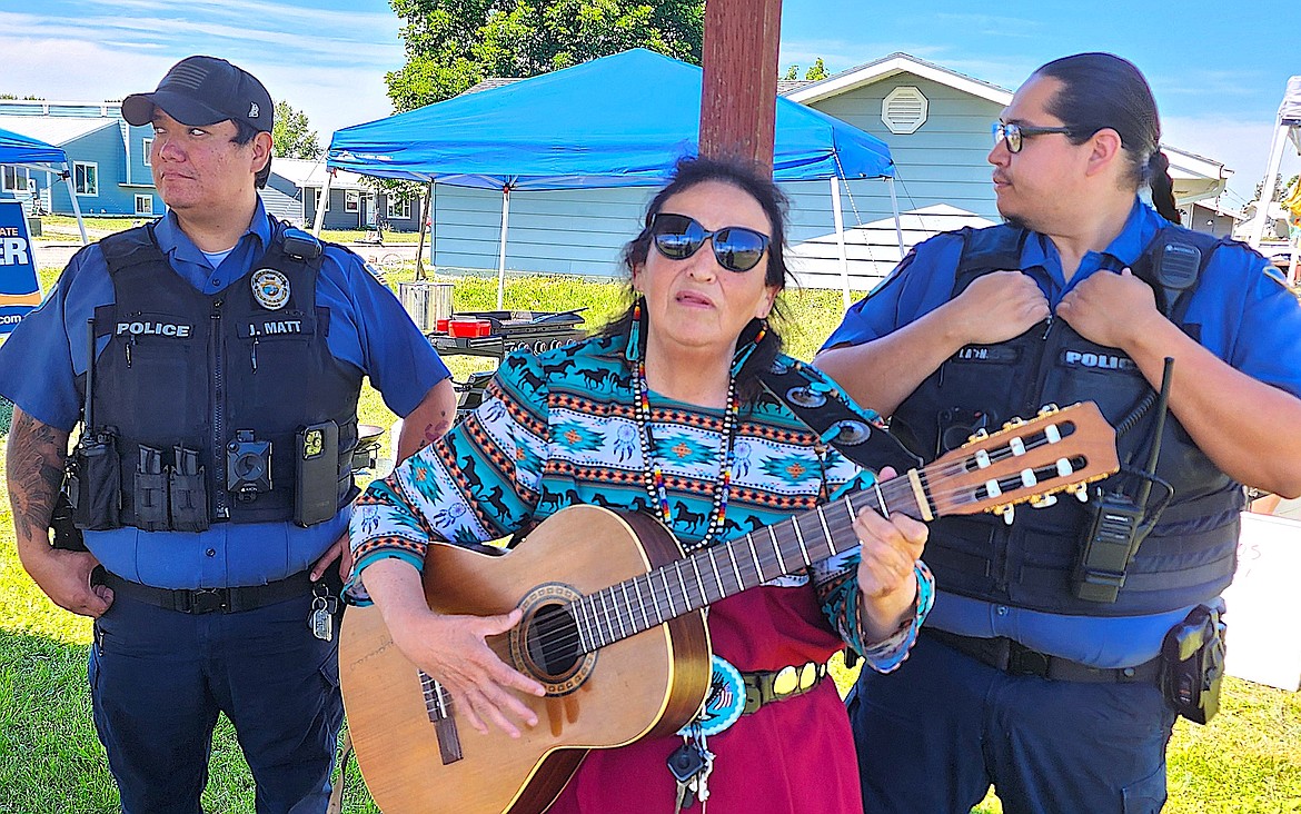 Native singer Gen Huitt sings at the gathering for Senator Jon Tester on Sunday afternoon. She stands between Flathead Tribal Police officers Joe Matt, left, and Isaiah Ascencio. (Berl Tiskus/Leader)