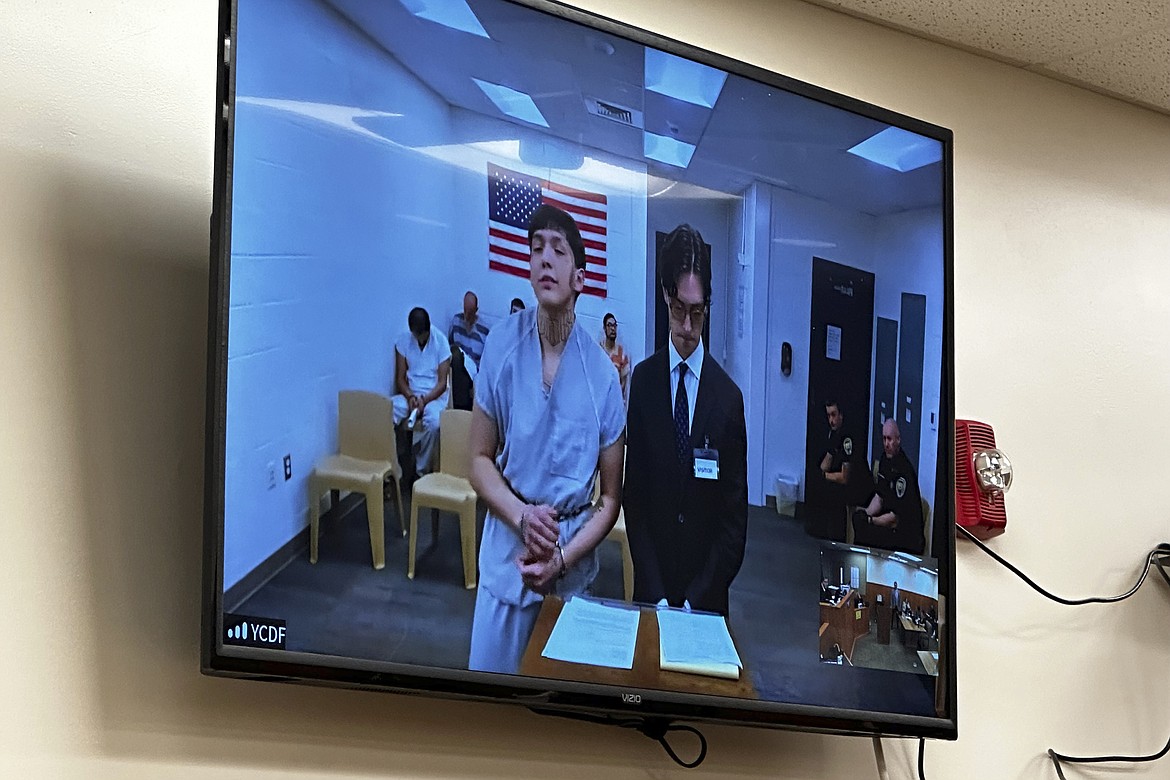 Myron Scott Goes Ahead, left, is seen on a video monitor during a court appearance with his public defender, Tuesday, June 25, 2024, in Billings, Mont. Goes Ahead and Ashtin Glen, both inmates at the Yellowstone County jail, pleaded not guilty to attempted murder after they allegedly attacked officers with makeshift weapons, sending one to the hospital. (AP Photo/Matthew Brown)