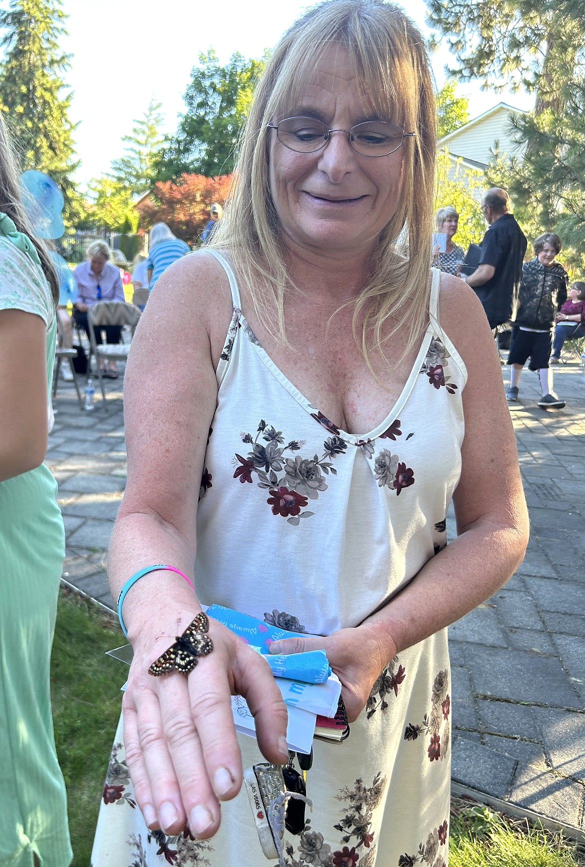 Christina Volk smiles as she looks at a butterfly on her hand during the Community Memorial Butterfly Release on Tuesday.