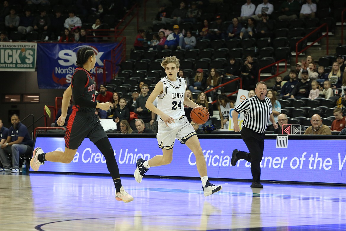 MLCA/CCS sophomore Johnny Ferguson, in white, dribbles the ball up the floor during the 1B Boys State Basketball quarterfinals against Neah Bay at Spokane Arena. Ferguson was in his first year as a full-time starter with the Lions in 2023-24, and led the team in scoring.