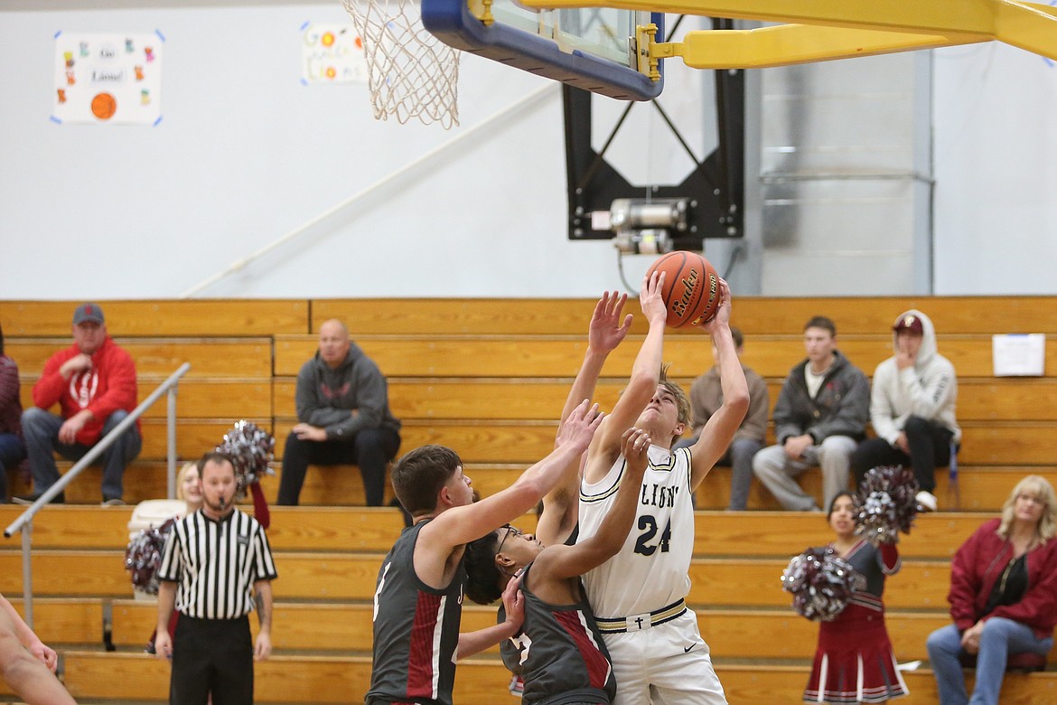 MLCA/CCS sophomore Johnny Ferguson, in white, fights through contact against Waterville-Mansfield during a game in the 2023-24 season. Lions Head Coach Emerson Ferguson said one of the sophomore’s strengths has been attacking the basket.